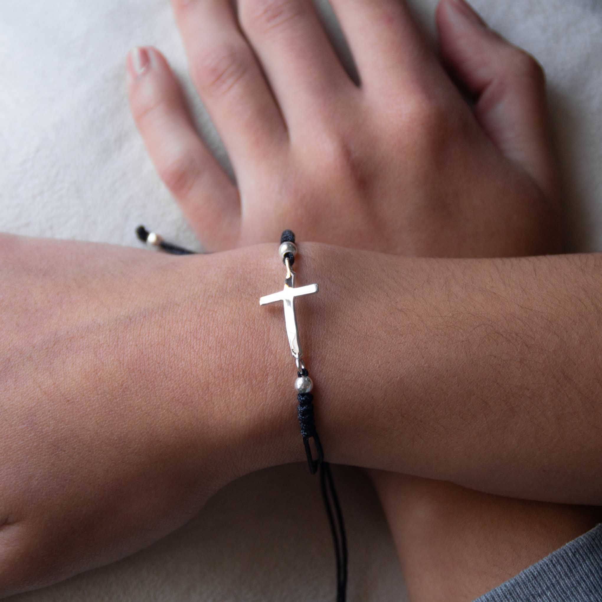 Bracelet of thread with silver cross